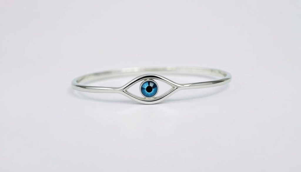 A sleek, silver-toned evil eye bracelet rests on a clean, minimalist background. The bracelet's surface gleams with a polished finish, its intricate eye-shaped design casting a mesmerizing gaze. Soft, diffused lighting illuminates the bracelet, highlighting its dimensional details and the delicate metalwork. The bracelet is positioned at a slight angle, allowing for a clear view of its size and scale. The background is a solid, neutral color, keeping the focus entirely on the captivating evil eye accessory.